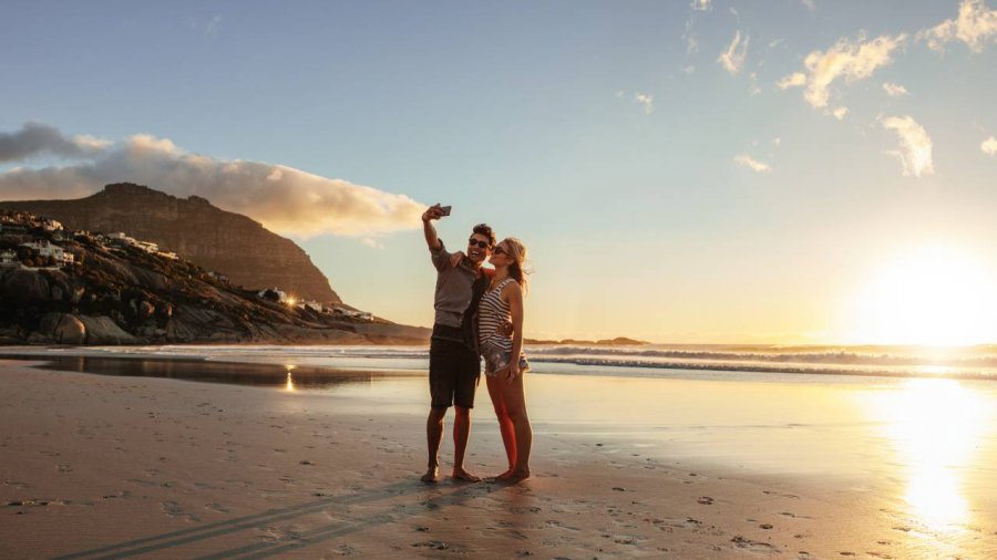 coppia in spiaggia scatta un selfie
